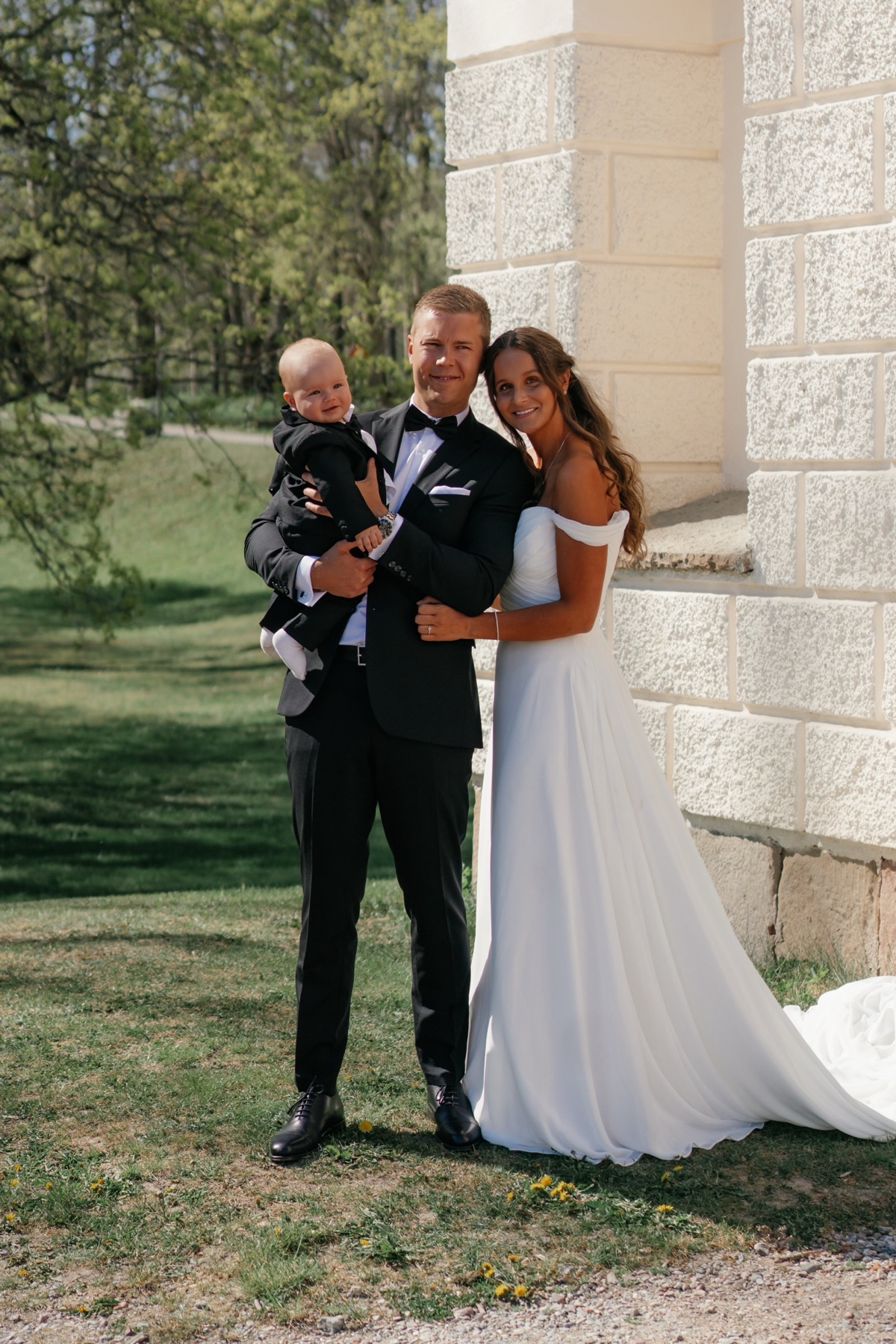 Emilia och Adam utanför en stenkyrka på sin bröllopsdag