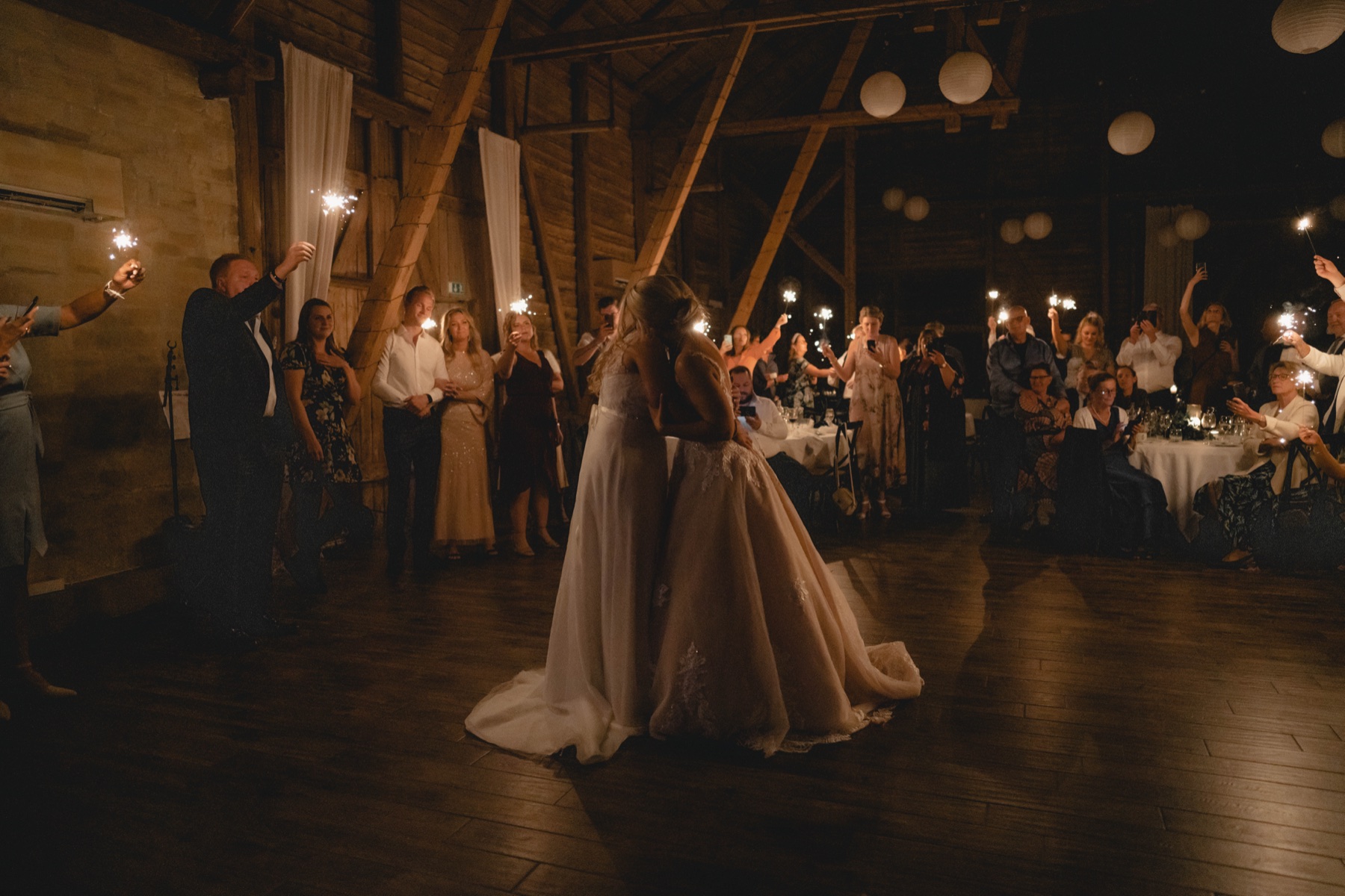 Brud som dansar under ljusslingor i en lada